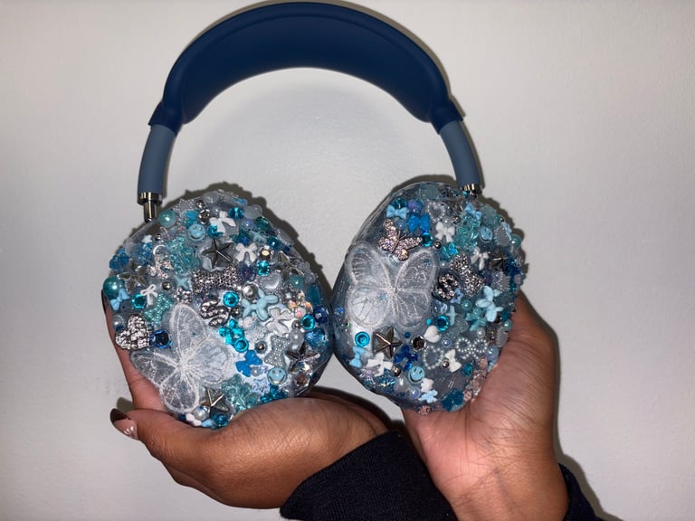 Close-up of hands holding bedazzled blue and silver headphones with crystalline embellishments